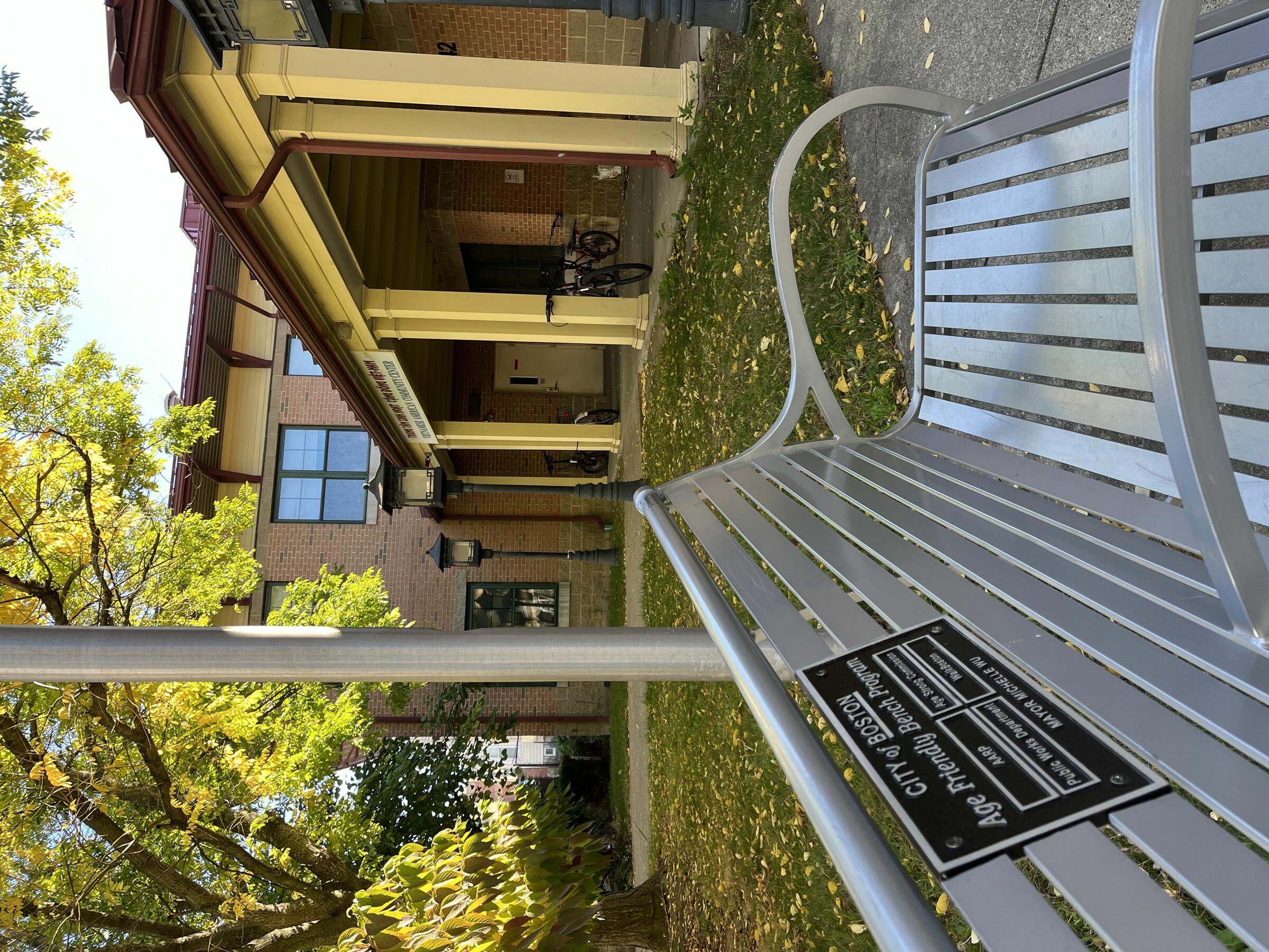 Metal bench in front of the Vietnamese American Community Center, placed as part of the Age Friendly Bench Program of the City of Boston.