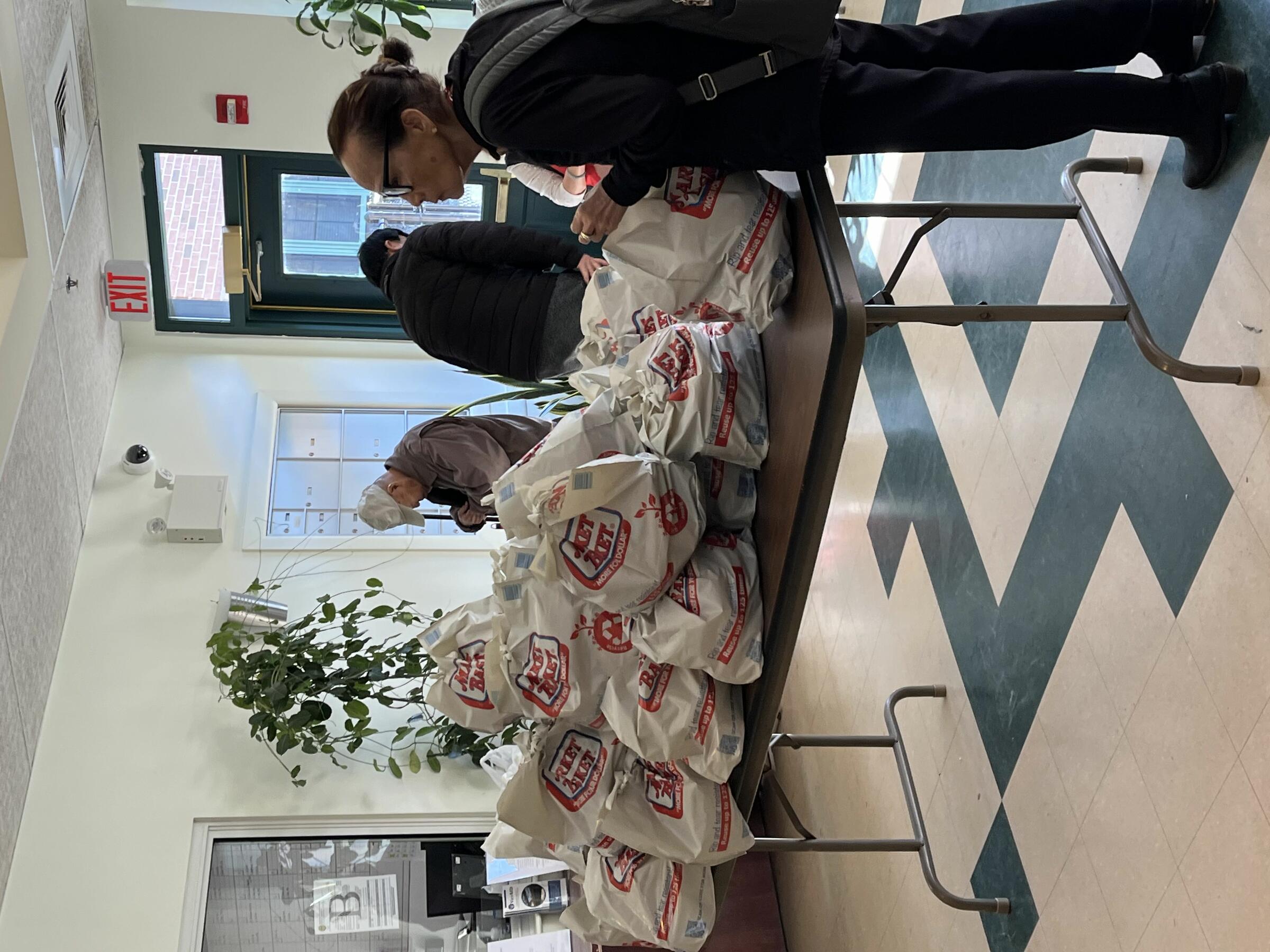 VietAID community program participants  working with bags of food from Market Basket.