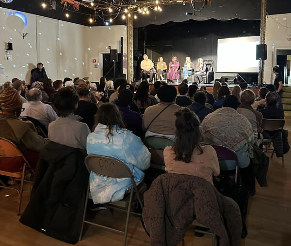 A group listens to panelists at the Co-Purchasing Potluck