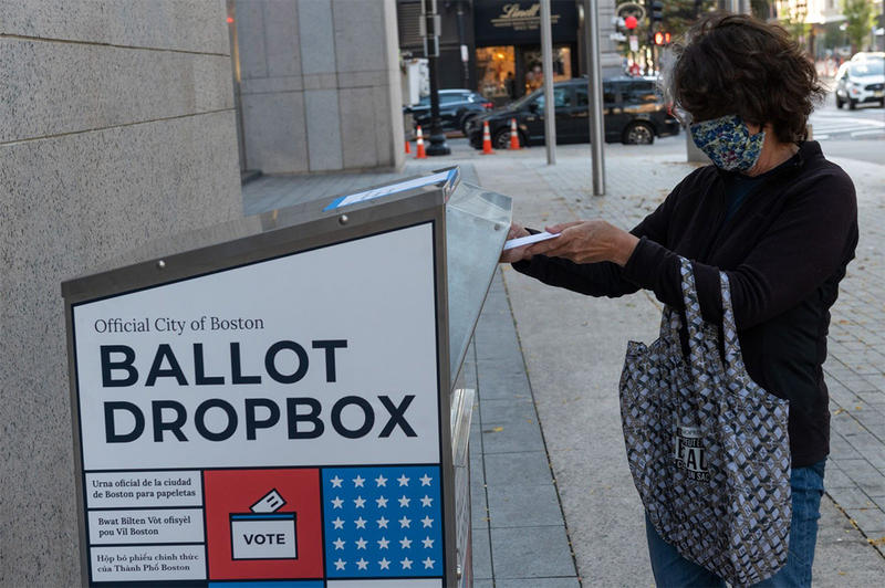 A voter using a ballot dropbox in the City of Boston