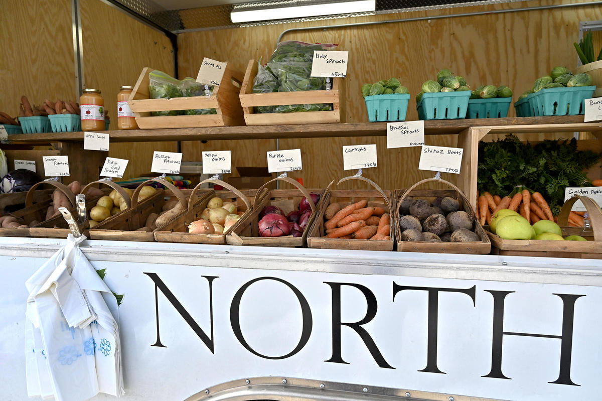 A picture of a farmers market stand with assorted vegetables