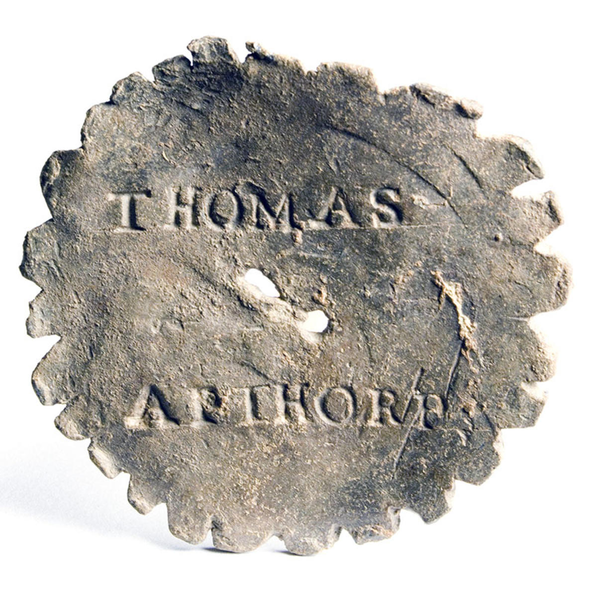 A lead whizzer toy with the name Thomas Apthorp stamped into the front