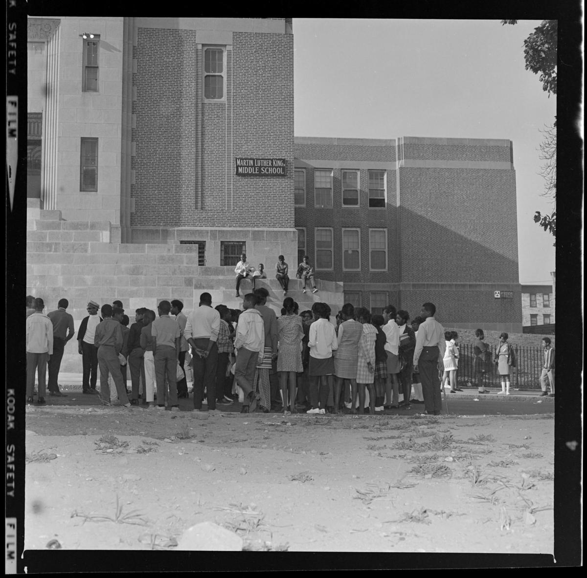 Black and white photograph of students standing out of Martin Luther King Jr. Middle School in Dorchester.