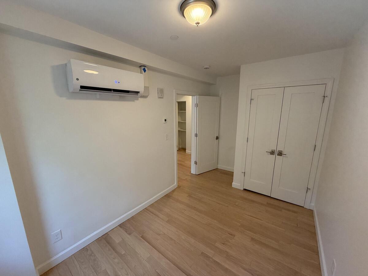 Room with hardwood floors and a large closet.