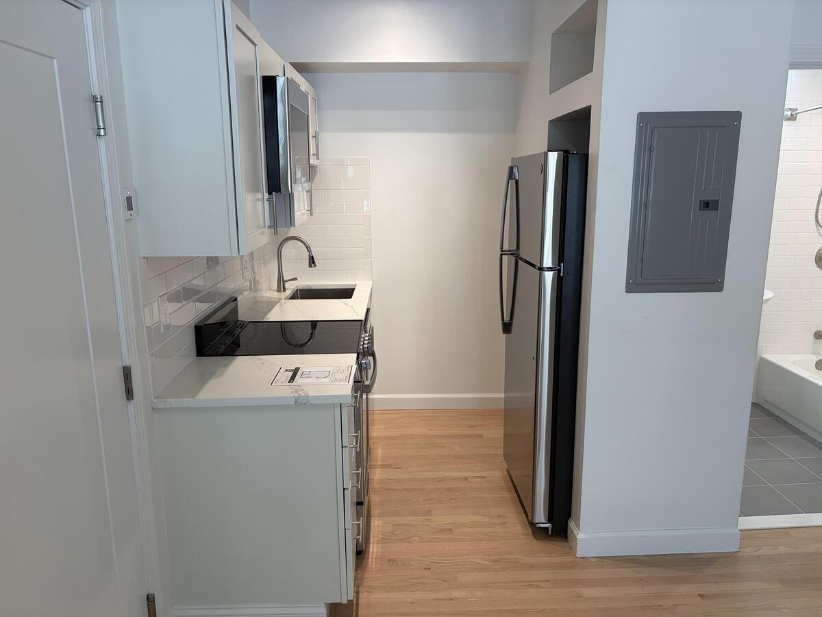 Small modern kitchen with stainless steel appliances.