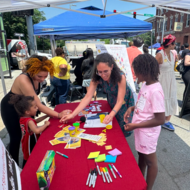 A Common SENSES Team member guides Boston residents through an environmental sensor activity.