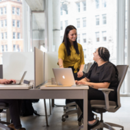 Staff members working in-person in an office workspace