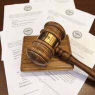 Gavel resting on stack of Council meeting agendas