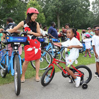 Mayor Wu stands with some children on bikes